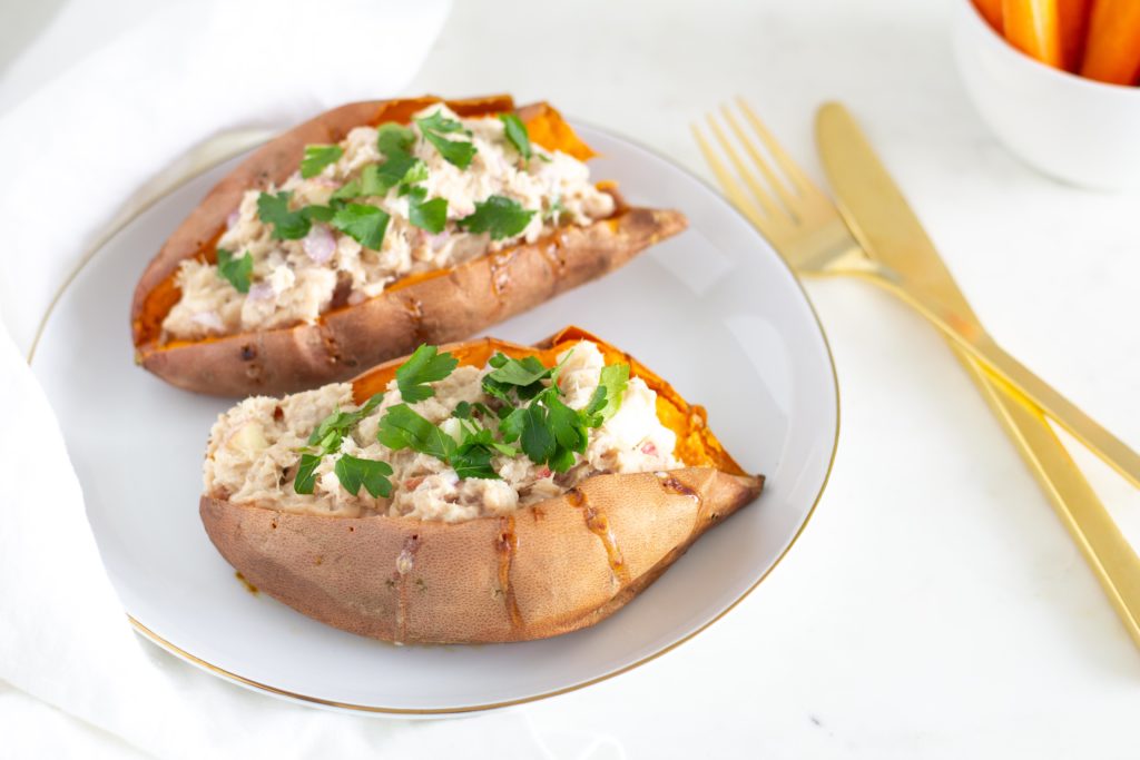 two baked sweet potatoes stuffed with tuna dip