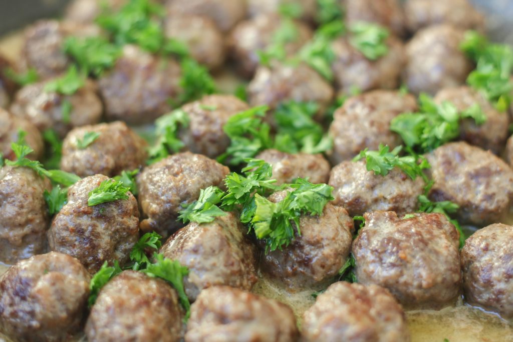 close up of Swedish meatballs in  a cream sauce with parsley