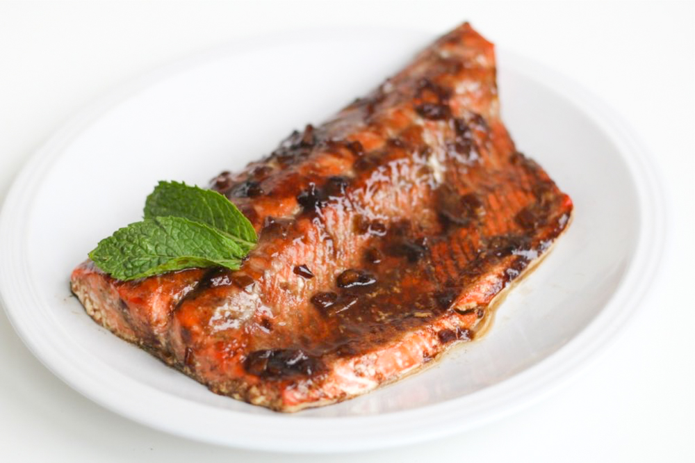 white plate with a large piece of glazed salmon