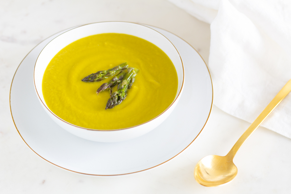 white plate with a creamy asparagus soup