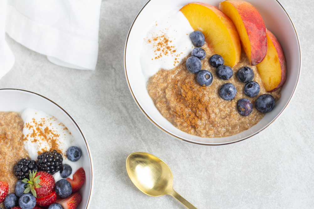 two bowls with oatmeal berries and peaches