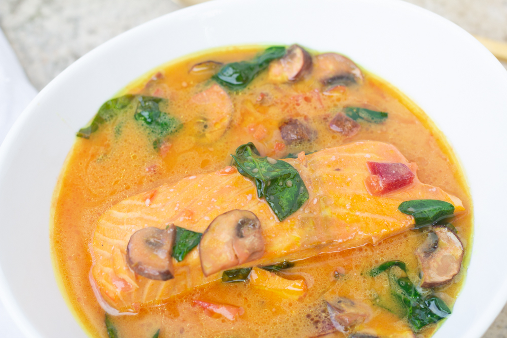 Bowl of thai coconut curry soup with salmon